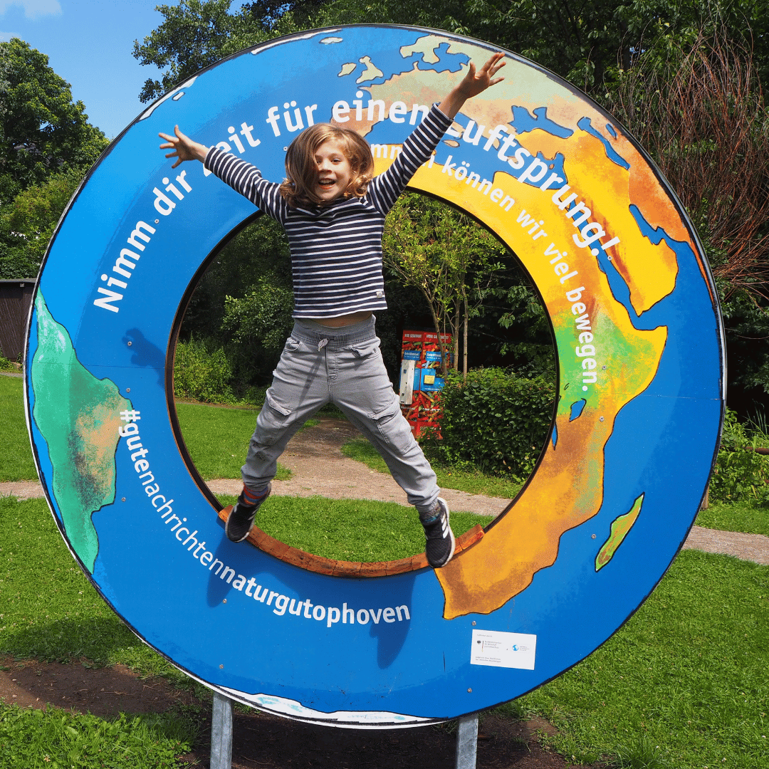 Kind macht Luftsprung durch einen großen Ring