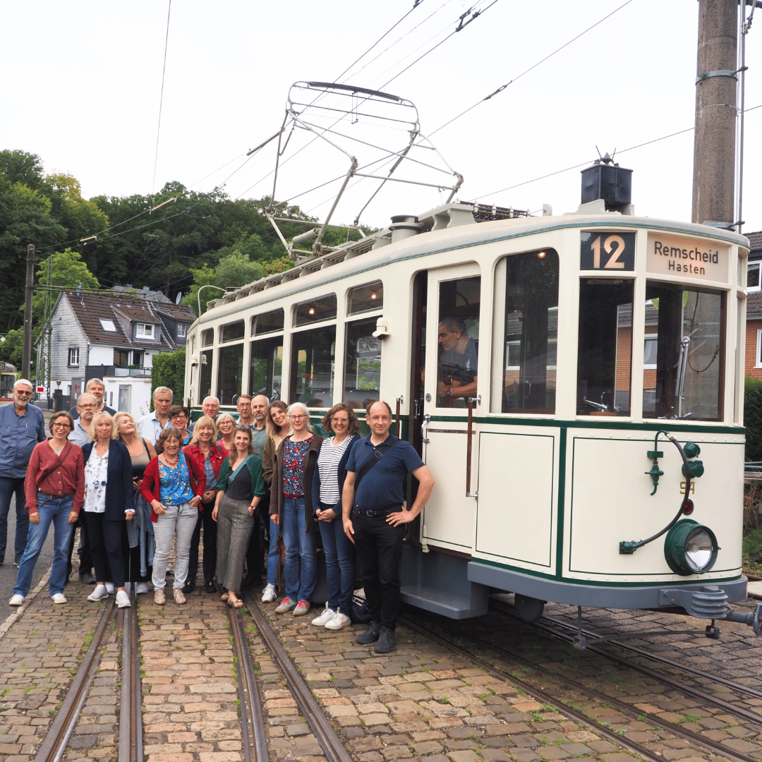 Die Netzwerkmitglieder vor einer historischen Straßenbahn