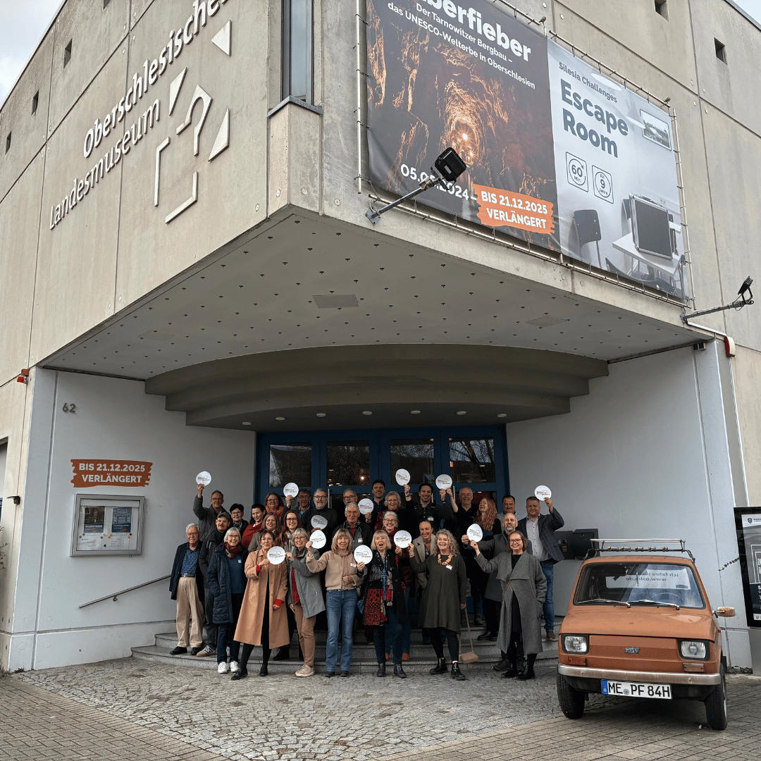 Gruppenfoto vor dem Eingang des Museums, ein alter Fiat steht an den Seite